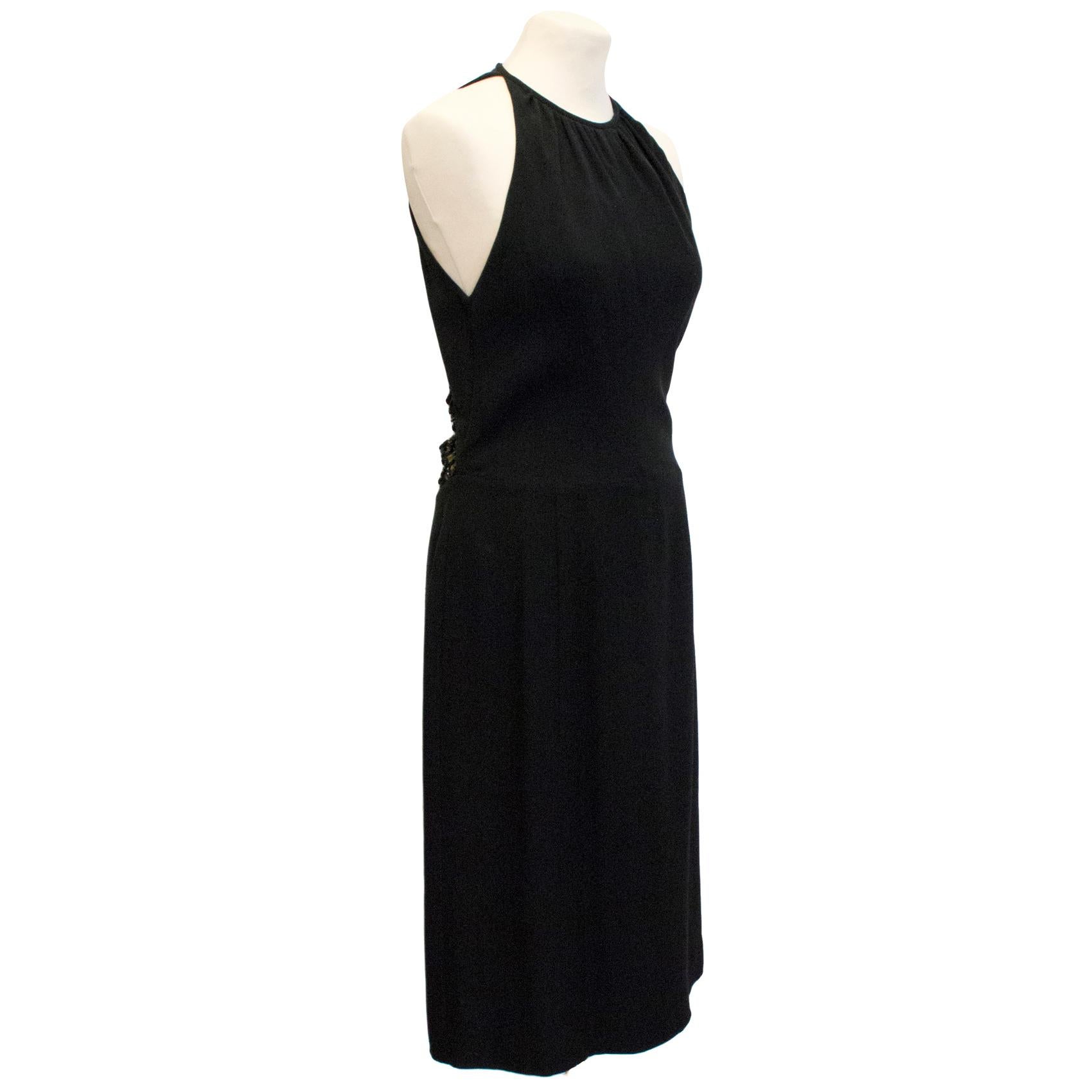 Valentino black beaded cocktail dress. Sleeveless. Low cut back with beaded embellishment. Fastens at the side with a hidden zip. High neckline. 

Please note: Some marks on the interior of the dress, see image 6, unnoticeable when worn. Some loose