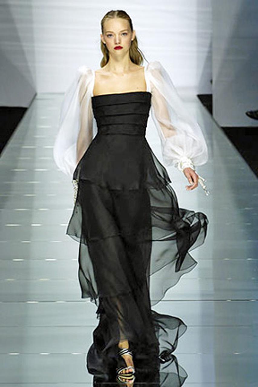 Valentino black and white silk organza gown. Body of dress fashioned of tiered black silk organza. White silk organza billowy bishop sleeves trimmed with beaded satin tassels at wrist. A stunning original runway piece from the noted designer