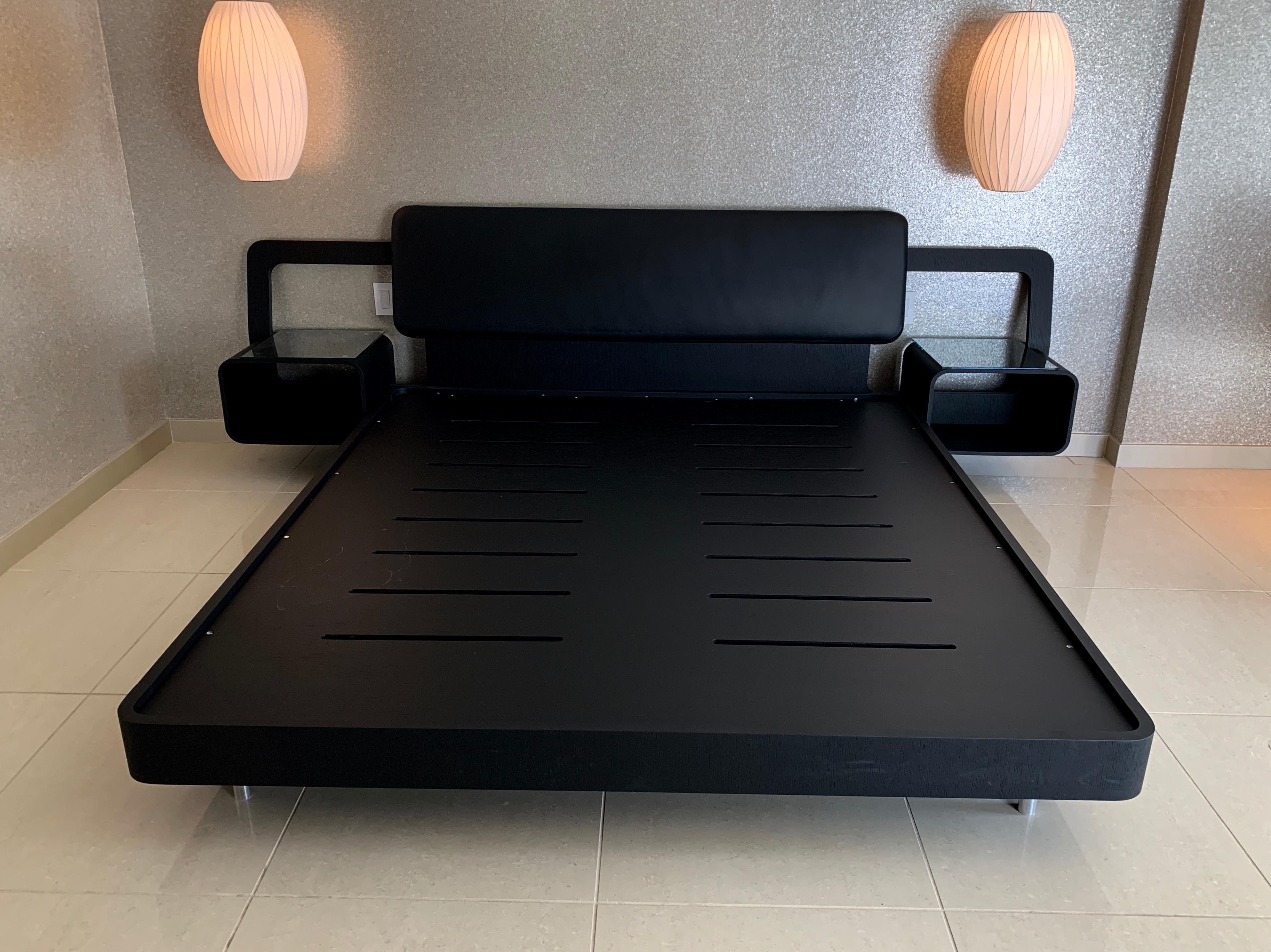 A King bed frame with attached nightstands by Property Furniture. It is a Valentino frame and is wood with leather. This custom made bed was handmade in Italy. Glass tops for the night stands have been added. interior mattress size is 79x71 inches.