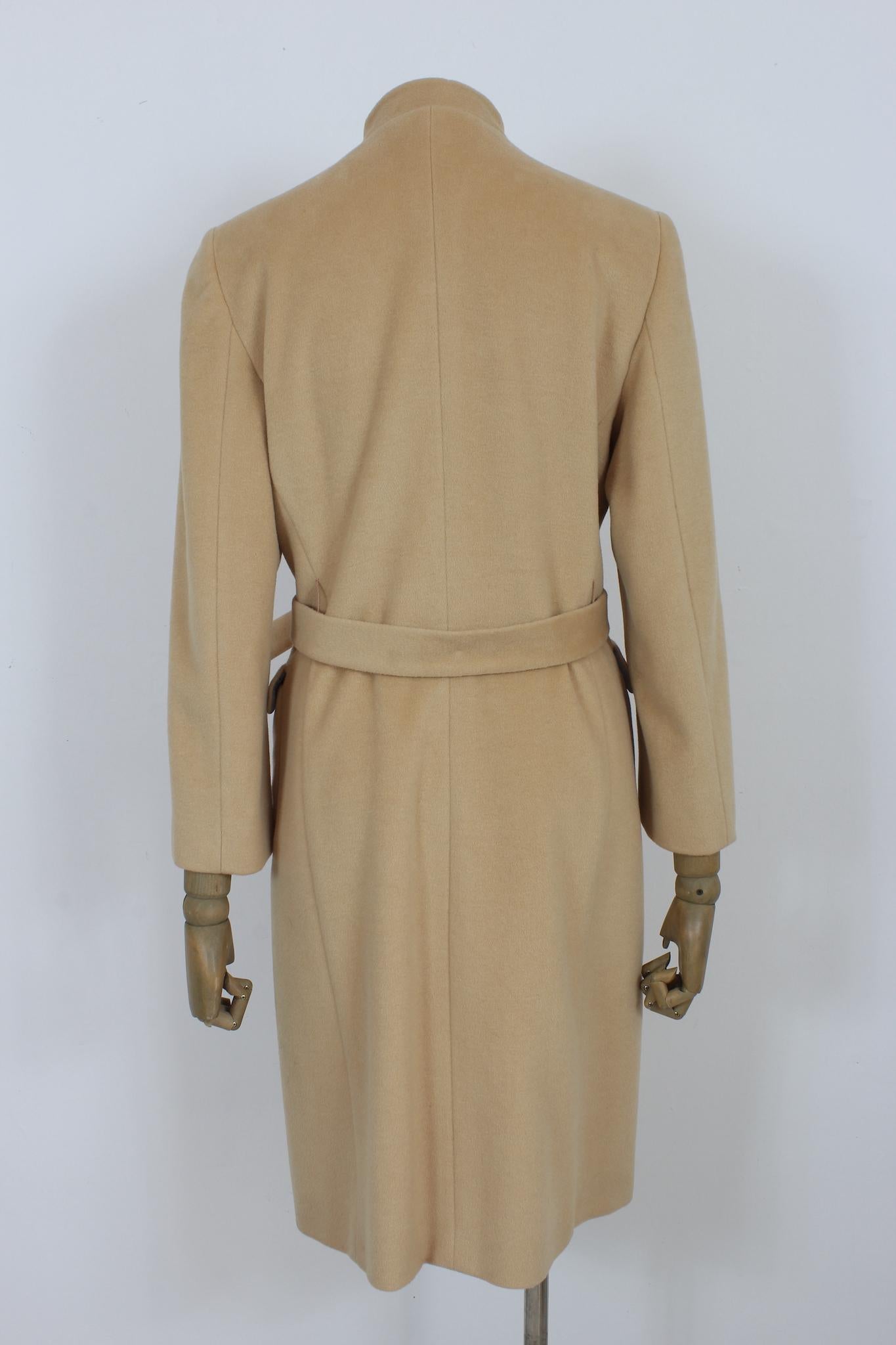 Valentino 2000s beige long coat. Double-breasted model with golden buttons. Adjustable waist belt. 50% wool, 30% angora, 20% silk fabric, internally lined. Made in italy.

Size: 42 It 8 Us 10 Uk

Shoulder: 42cm
Bust/Chest: 49 cm
Sleeve: 57