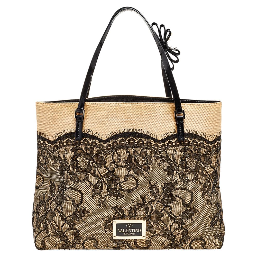 Valentino creations are full of elegance and modern aesthetics. This tote from the Italian fashion house is impeccably designed in lace, patent leather, and raffia with sleek top handles and a shoulder strap. Carry it for light travel or while