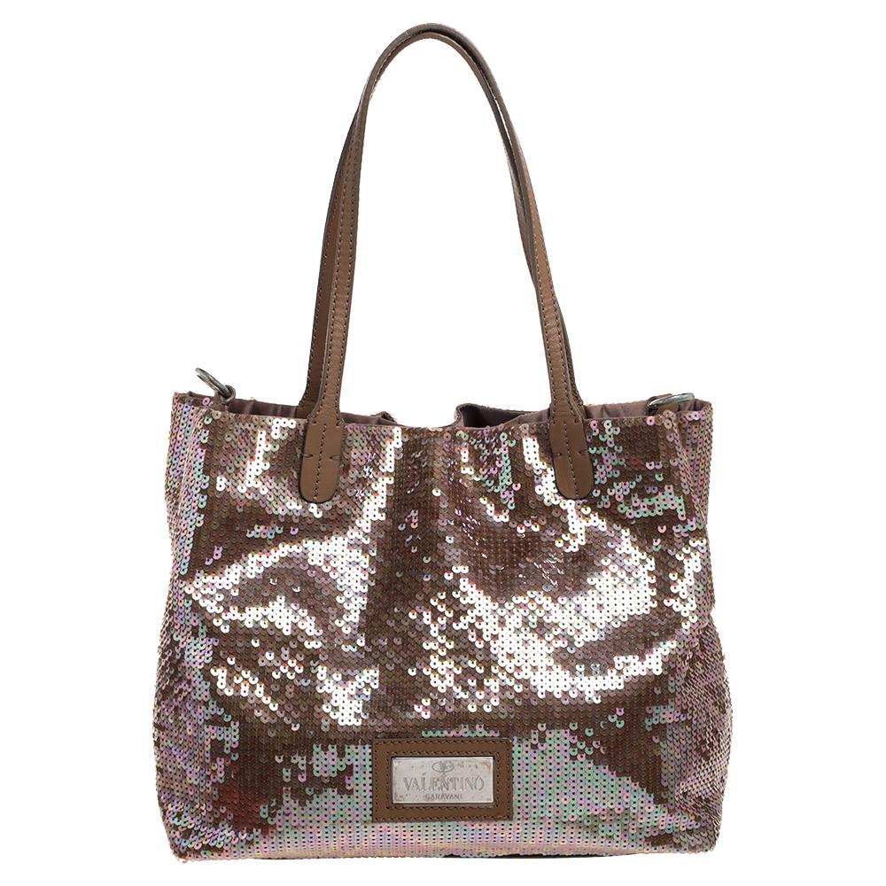 Bags like these are hard to come by, so quickly grab one when you can! Crafted from beige leather and bronze sequins, this bag by Valentino features a beautiful rose detailing on the front. Equipped with dual leather handles, it has a luxurious