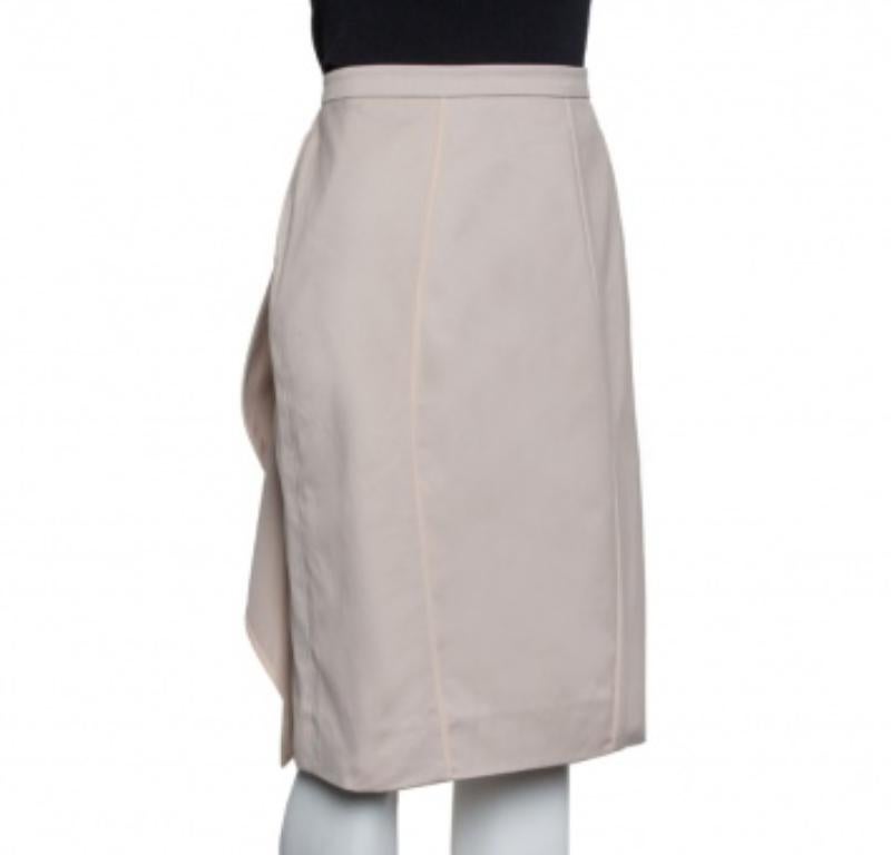 Beige is a wonderful color that can be styled with ease and when worn as a fitting skirt can project a refined look. This Valentino creation is a simple knee-length skirt with a ruffle panel. The back zip fastener secures the skirt well.