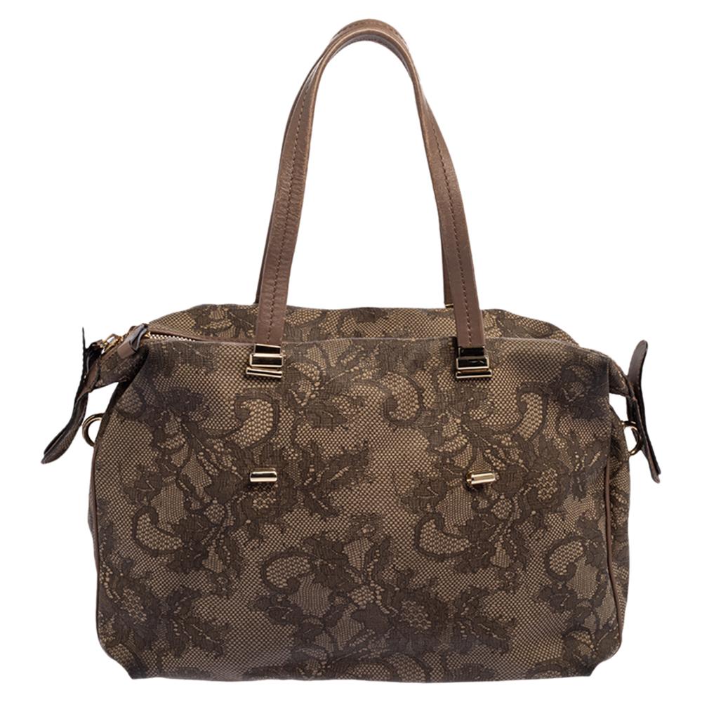 Lend effortless elegance to your accessories collection with this satchel bag from Valentino. It is fashioned in floral lace coated canvas with leather trim and has top handles for carrying ease. It has a zip-enclosed fabric interior with patch