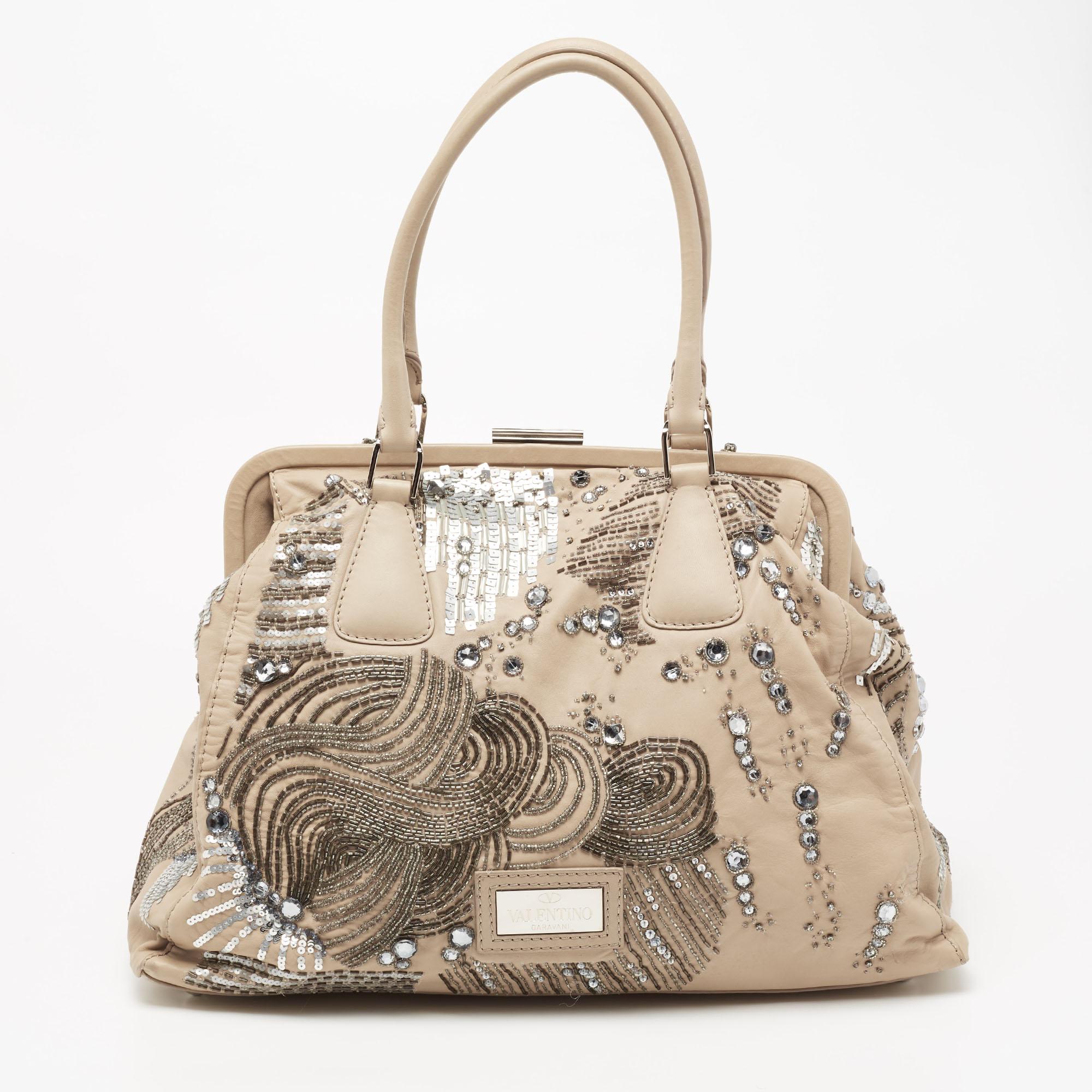 Ensure your day's essentials are in order and your outfit is complete with this Valentino bag. Crafted using leather, the bag has beautiful embellishments, two handles, frame-top closure, and a satin-lined interior.

Includes: Original Dustbag
