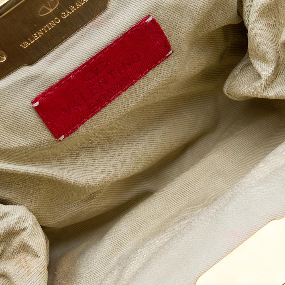 Diese schöne Tasche von Valentino aus beigem Leder hat einen minimalistischen Charme. Er ist dafür gedacht, in der Hand oder auf der Schulter getragen zu werden. Das Innenleben aus Stoff bietet Platz für Telefon, Kartenhalter und Lippenstift.

