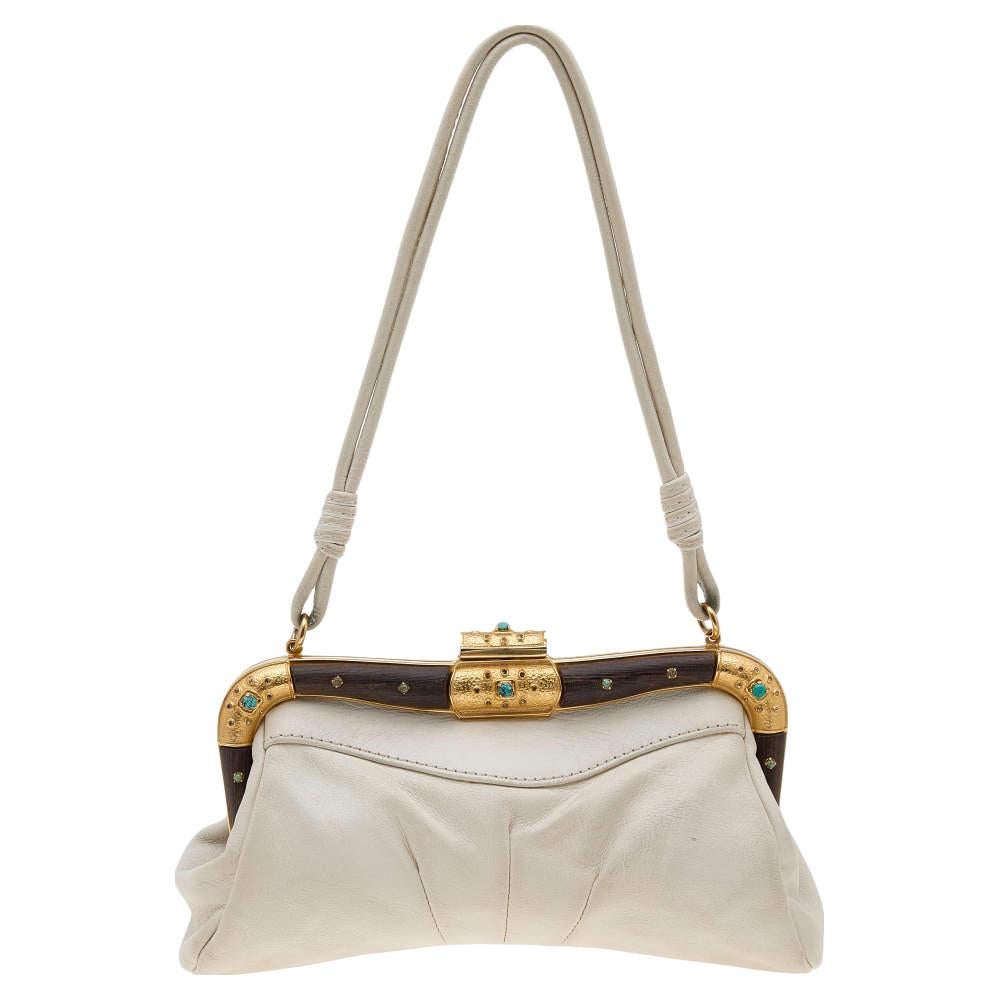 This beautiful bag by Valentino in beige leather has a minimalistic appeal. It is meant to be carried in your hand or on your shoulder. The fabric interior ensures room for your phone, cardholder, and lipstick.

