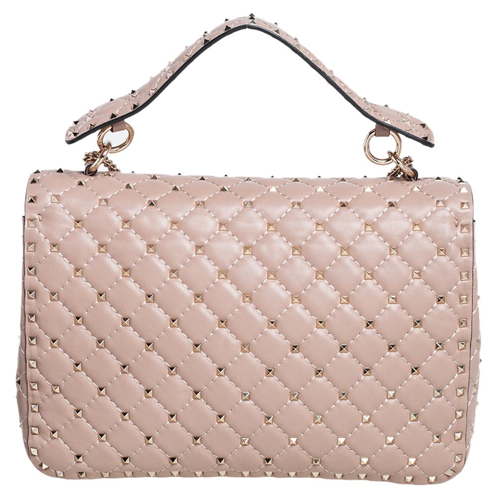 Catch admiring glances when you carry this Rockstud Spike bag from Valentino! Crafted well, the beige-hued bag has a top handle, a chain shoulder sling and it features the iconic Rockstuds detailed on the quilted leather exterior. The front flap