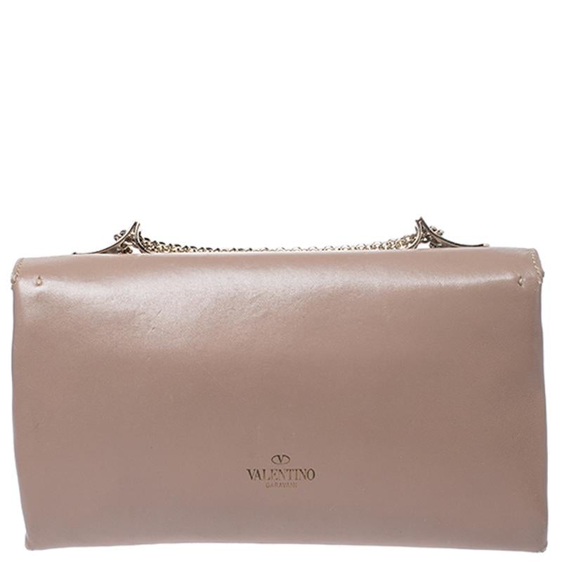 This Va Va Voom bag from Valentino has a pretty captivating design. Crafted from leather, the bag features gorgeous a flap, a fabric interior, and a shoulder chain. It also comes with a hand slot that is decorated with their signature pyramid