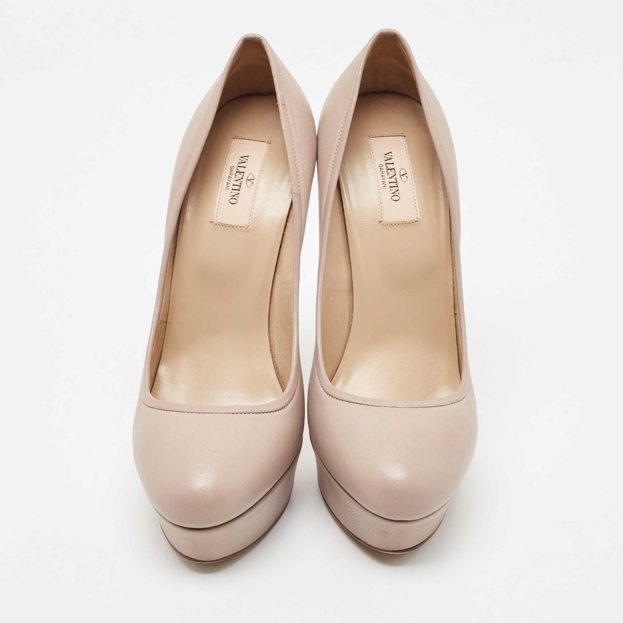 Lend an uber-chic look to your ensemble with this pair of Valentino pumps. Made from beige leather, they feature round toes and leather-lined insoles. These pumps are set on platforms and 11cm stiletto heels that will surely make heads