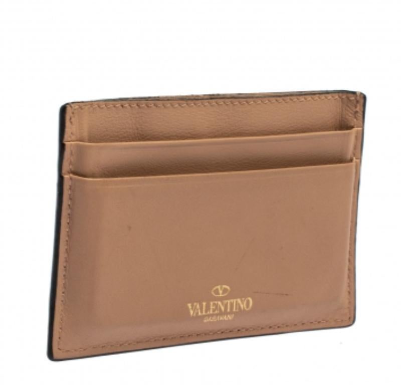 Valentino brings you this uber-chic creation to carry your cards in style. Crafted from quality leather and adorned with the iconic pyramid-shaped Rockstuds, this beige cardholder has multiple slots for your cards. This piece is sleek and easy to