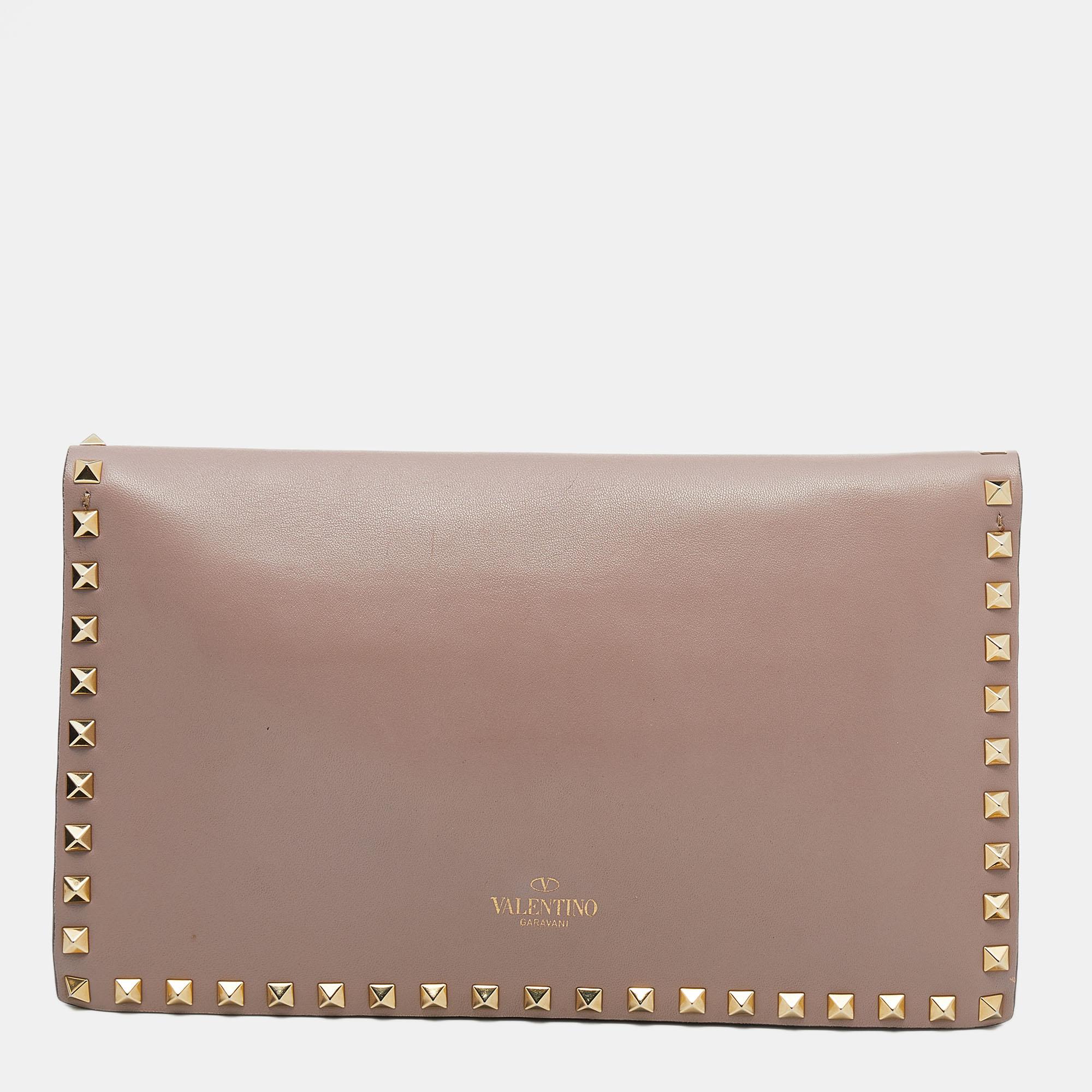 This Rockstud clutch from Valentino is made from beige leather. It brings Rockstud motifs on the exterior and a slot-detailed flap to secure the interior. It comes held by a wristlet and is perfect for evenings or day looks.