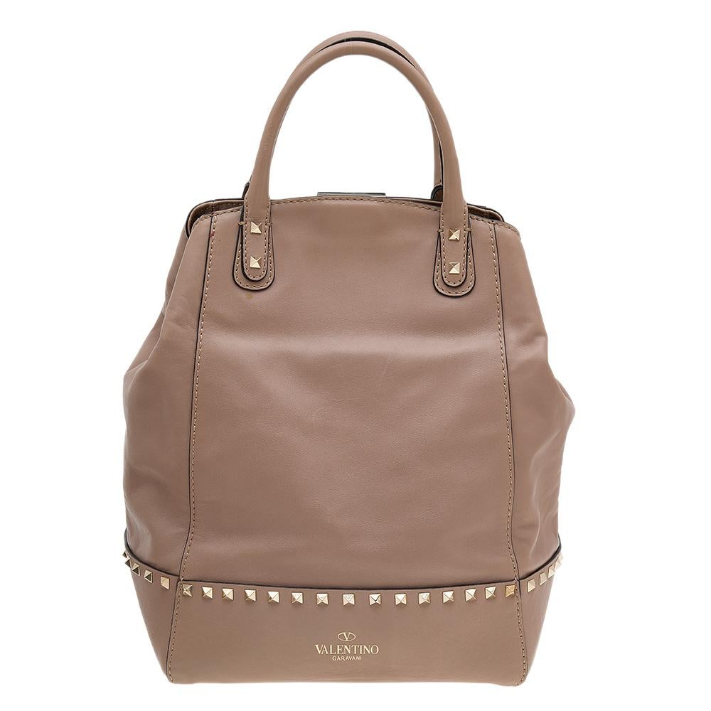 This beautifully stitched leather tote is by Valentino. It has a spacious size and two handles that are easy to hold. The designer tote is given a signature update with the Rockstud trims on the exterior.

Includes: Shoulder Strap
