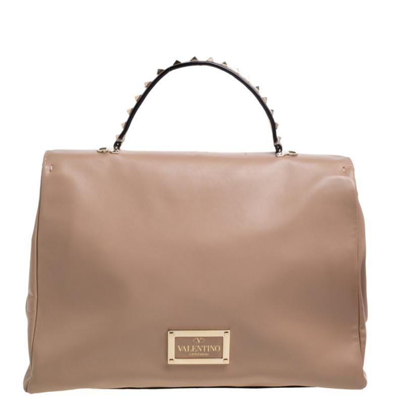Meticulously crafted from leather, this bag simply delights not only with its appeal but structure as well. It is held by a single handle, as well as a detachable shoulder strap, and equipped with a spacious interior. The fabulous shape, the famous