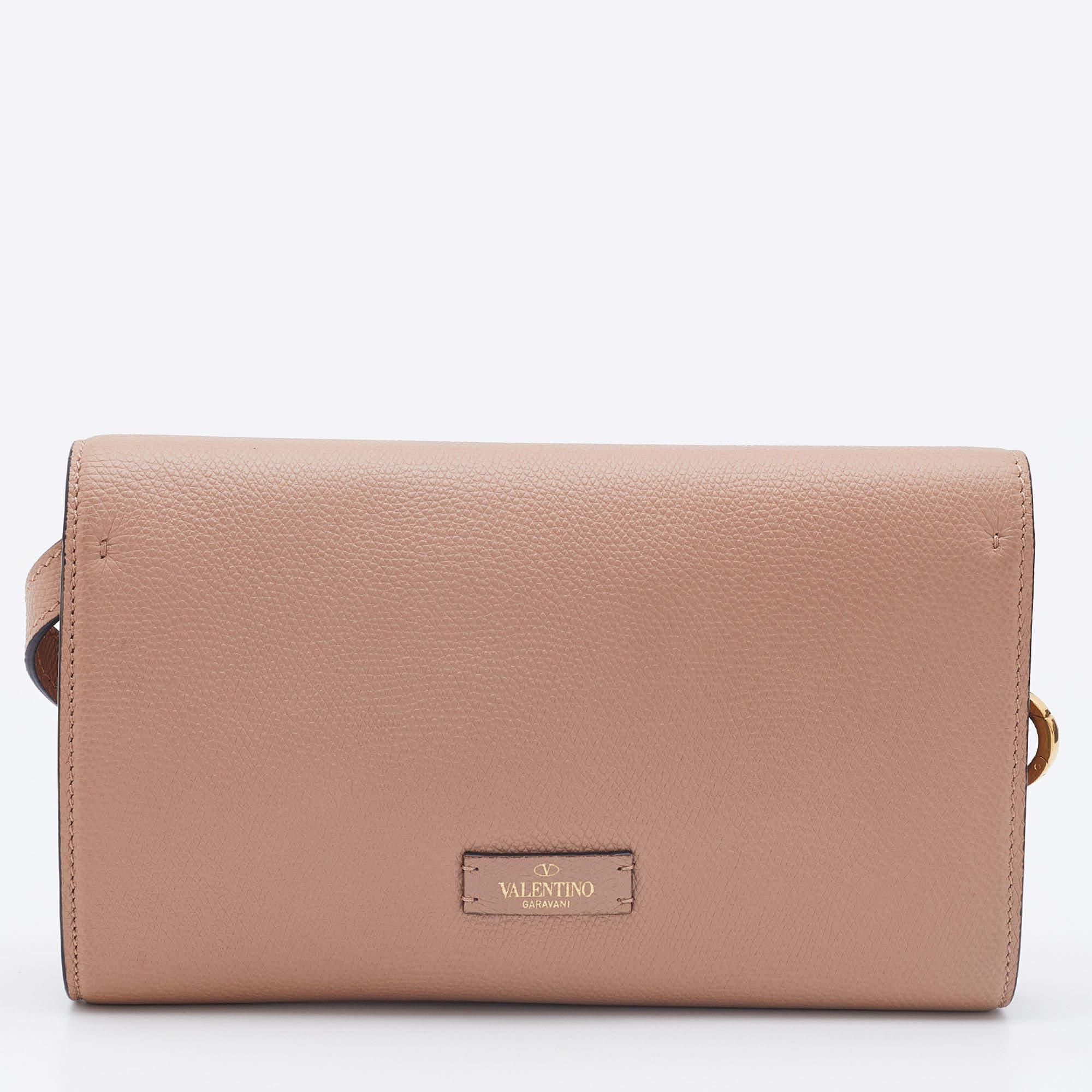 Valentino accessories are stylish, glamorous and classic. This Vsling by the iconic brand is perfect for a host of occasions and will make every outfit a success. Crafted from beige-hued leather, it has a sleek body with a front flap that carries
