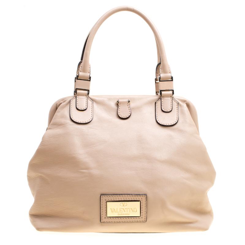 Valentino is known to bring out unique and one of a kind pieces year after year and this satchel is indeed one of them! It is crafted from beige leather and features an artistic silhouette. It flaunts a multicolour flower applique detailing at the