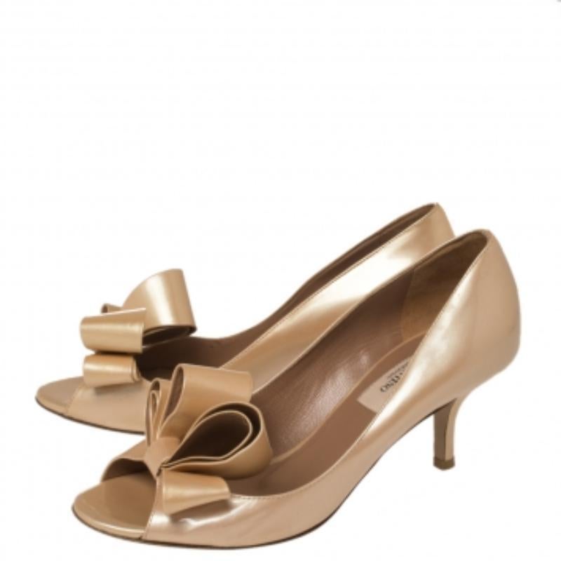 Create an aura of elegance with these peep-toe pumps from Valentino. These beige pumps are crafted from patent leather and feature a sophisticated silhouette. The pair flaunts a bow detailing at the front, leather-lined insoles, and a 7 cm heel.