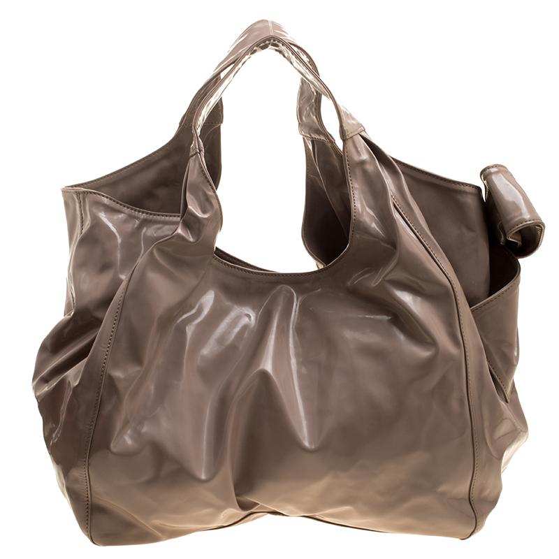 This Valentino hobo is durable and lovely to look at. It has been crafted from patent leather and is lined with satin. The bag has a spacious interior that will easily hold all your belongings and it is held by two handles. The hobo is complete with