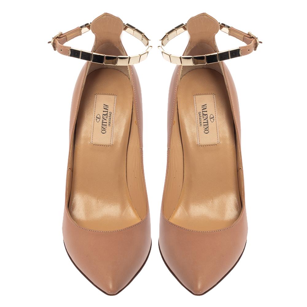 Make a flawless style statement while flaunting these beige-hued Valentino pumps. Made with high-quality patent leather, they feature chain detailed ankle straps that give a stylish makeover to the footwear. These pumps have pointed toes, extended