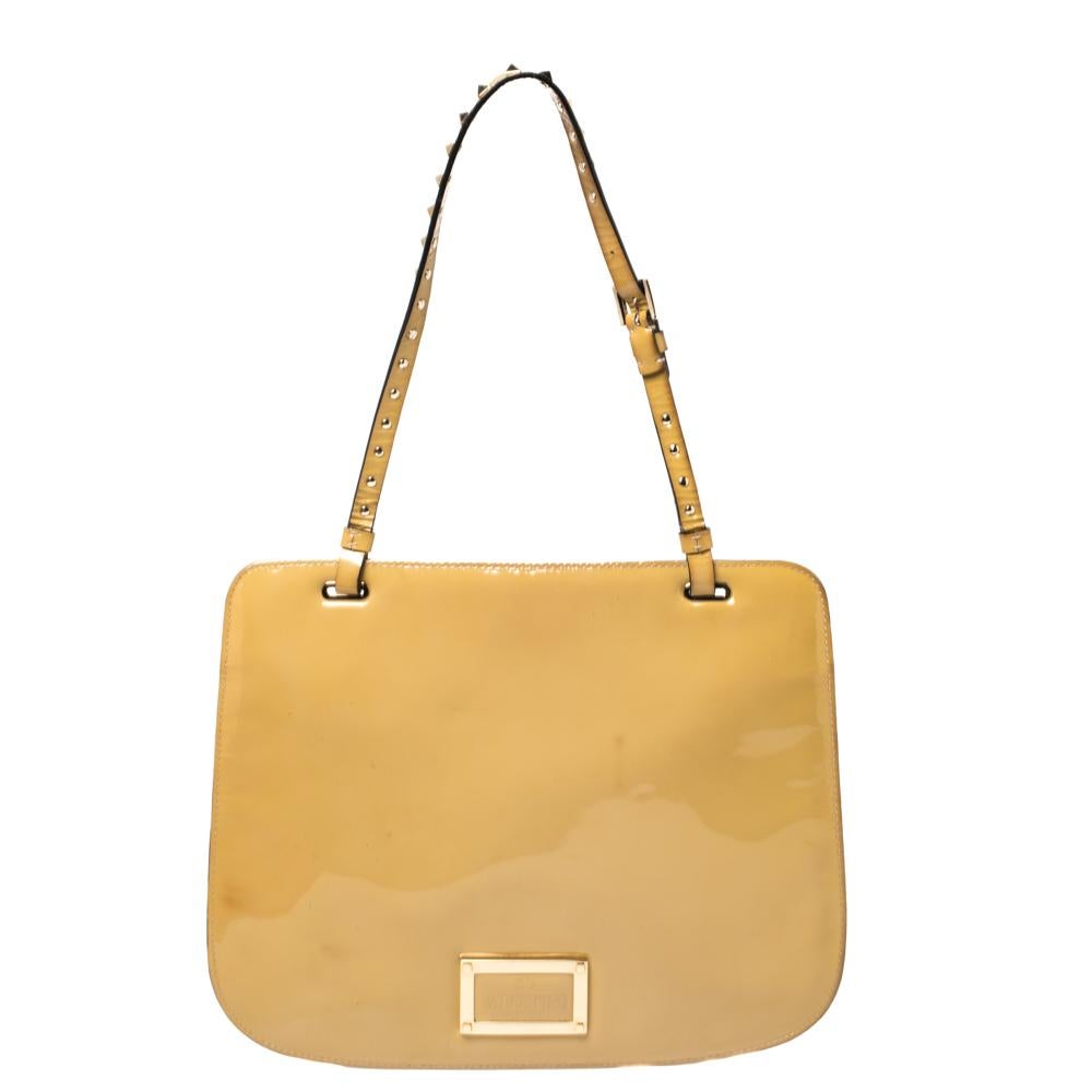 A designer shoulder bag to carry your essentials this season and the ones after. The lined interior and the Rockstud-detailed shoulder handle promise convenience. Valentino brings to you this stylish bag made from beige patent leather.

Includes:
