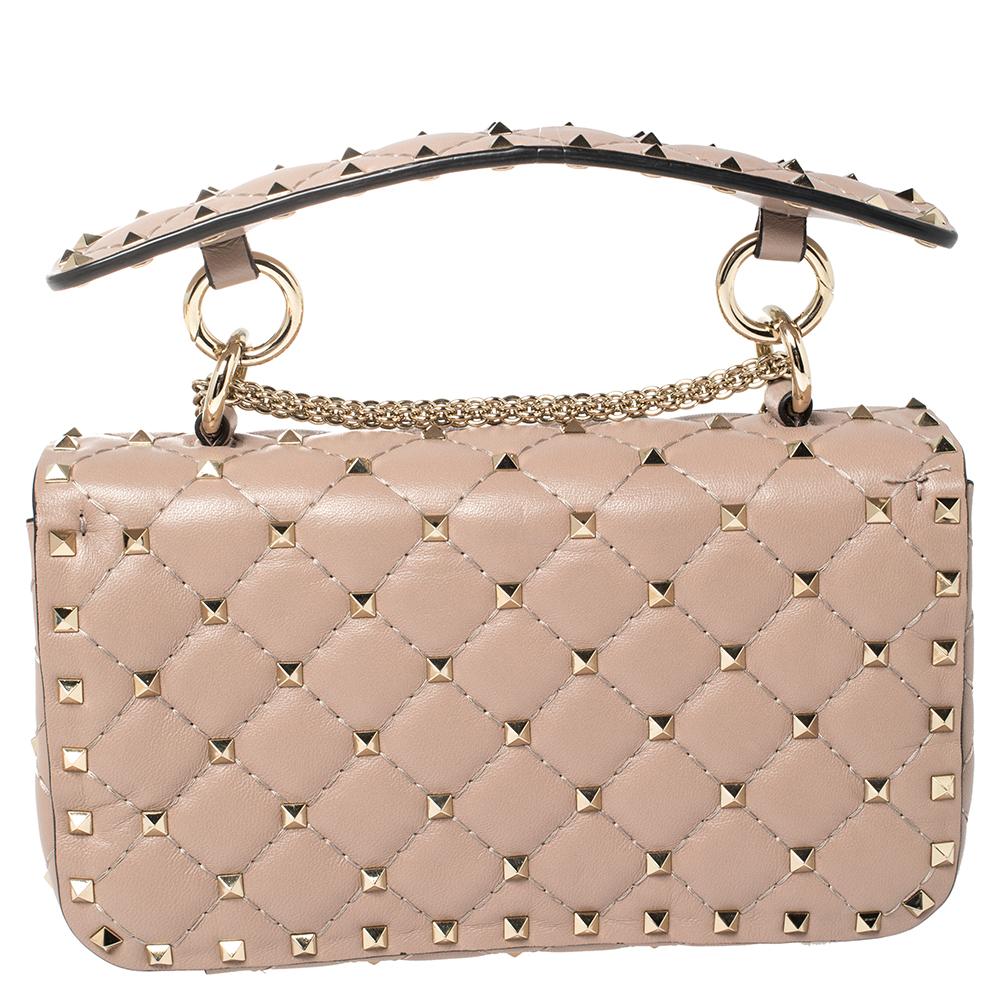 Let Valentino Garavani’s fashion-forward sensibilities take center stage with the iconic Spike bag – notice how the Rockstuds glow and sparkle against the beige quilted leather. Crafted in Italy, it is perfectly shaped to easily stow your everyday