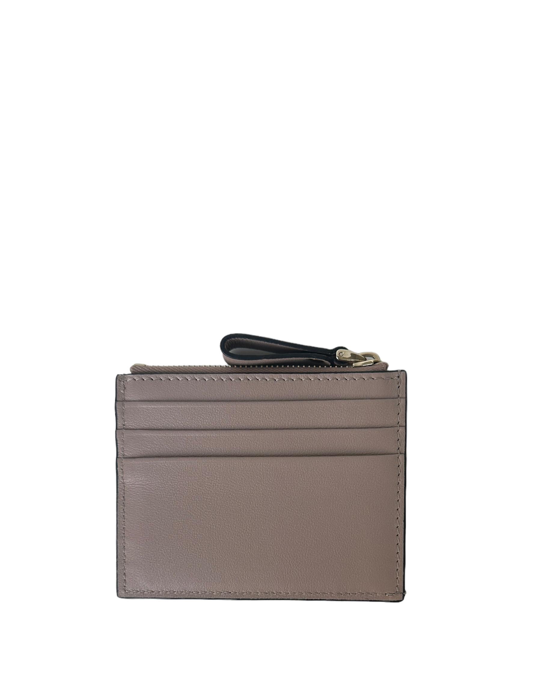 Valentino Beige Rockstud Zip Leather Card Case 

Made In: Italy
Color: Beige
Hardware: Goldtone
Materials: Leather
Lining: Canvas
Closure/Opening: Zip top
Exterior Pockets: Six credit card slots
Interior Pockets: One zip coin pocket
Exterior