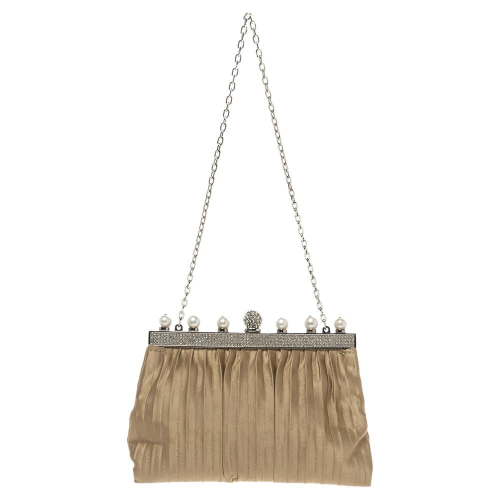 This clutch from Valentino is designed with satin and details of faux pearls and crystals. It features a frame top and its satin interior is sized to hold your little essentials. It comes held by a chain and is perfect for evenings.

