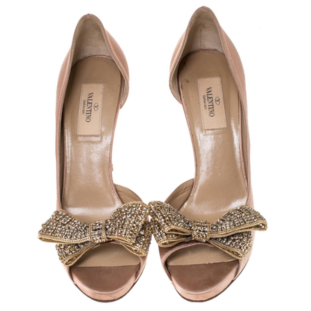 Designed by Valentino, this pair of pumps is shaped out of satin and is truly feminine. Make an audacious style statement while flaunting this pair of beige d'orsay pumps while heading to your next event. They are lined with leather and are