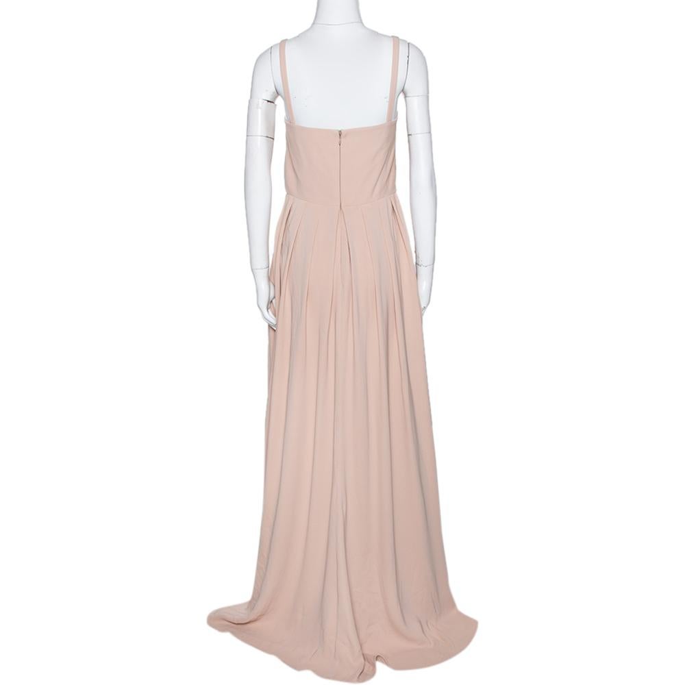 This maxi dress from the house of Valentino will make sure you look and feel special. This sleeveless number is soft and effortlessly feminine. The dress is tailored from silk and comes in a lovely shade of beige. It has thin straps, pleat detailing