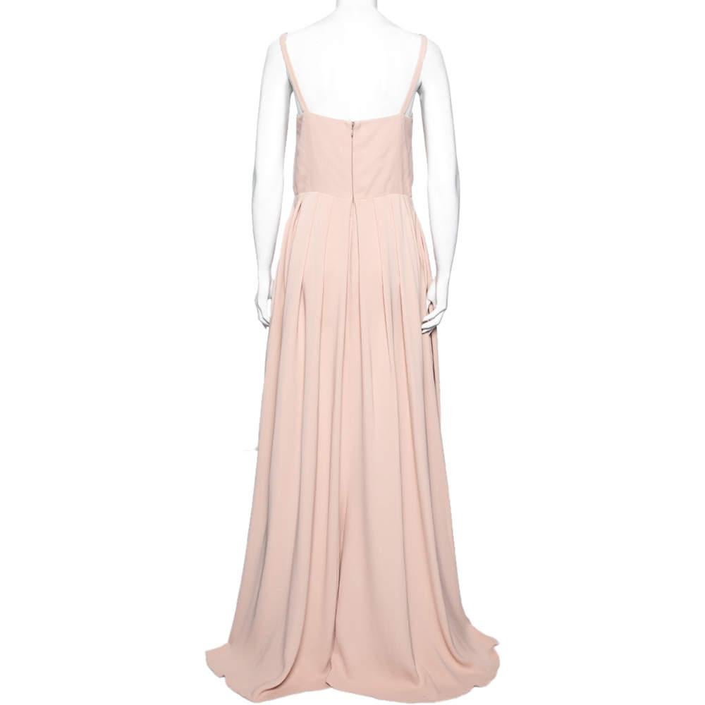 This maxi dress from the house of Valentino will make sure you look and feel special. This sleeveless outfit is soft and effortlessly feminine. The dress is tailored from silk and comes in a lovely shade of beige. It has pleat detailing that