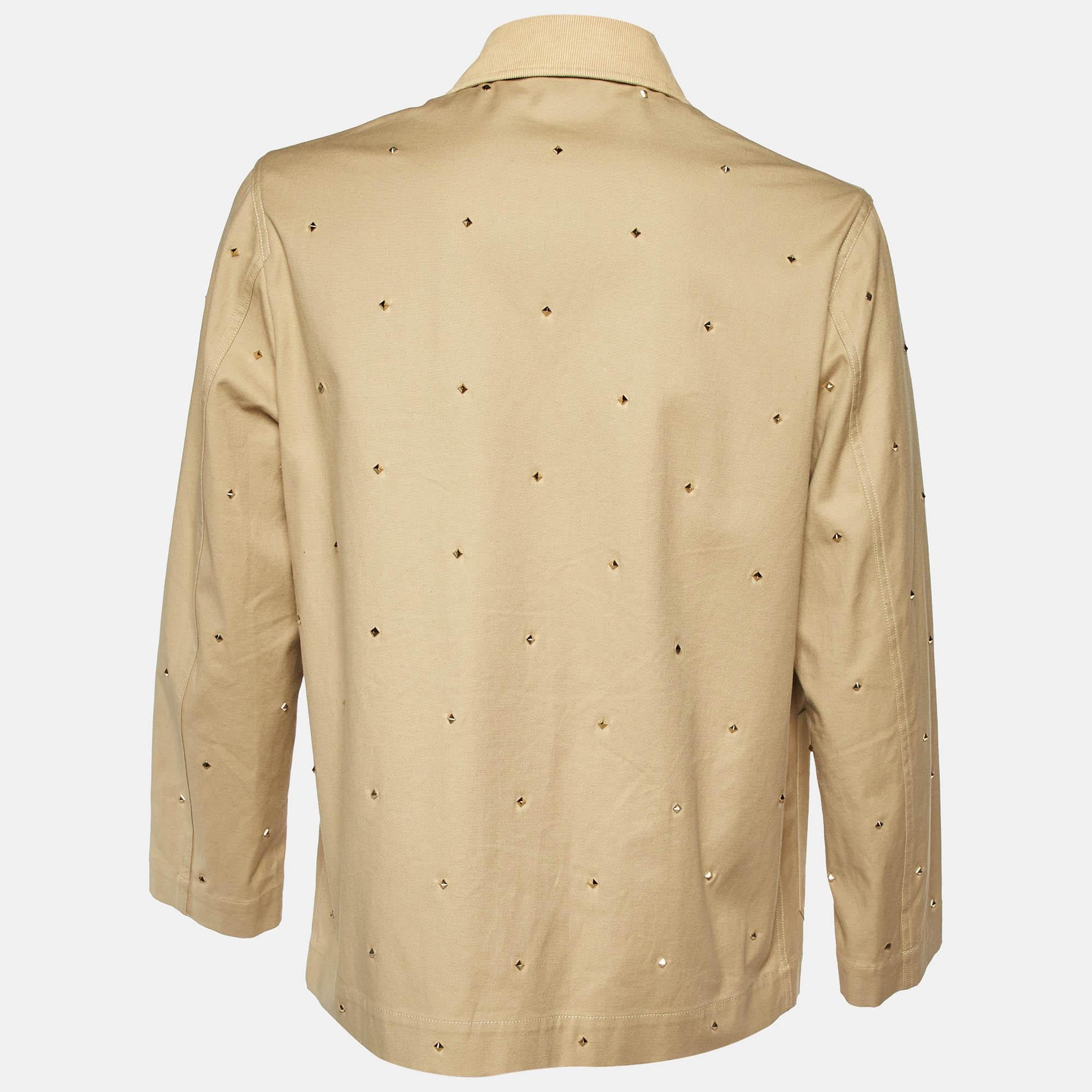 Questa giacca in cotone beige di Valentino offre la soddisfazione di una vestibilità comoda e di uno stile raffinato. È realizzato in cotone di qualità e ha una chiusura a zip.  due tasche  e dettagli chic con borchie.