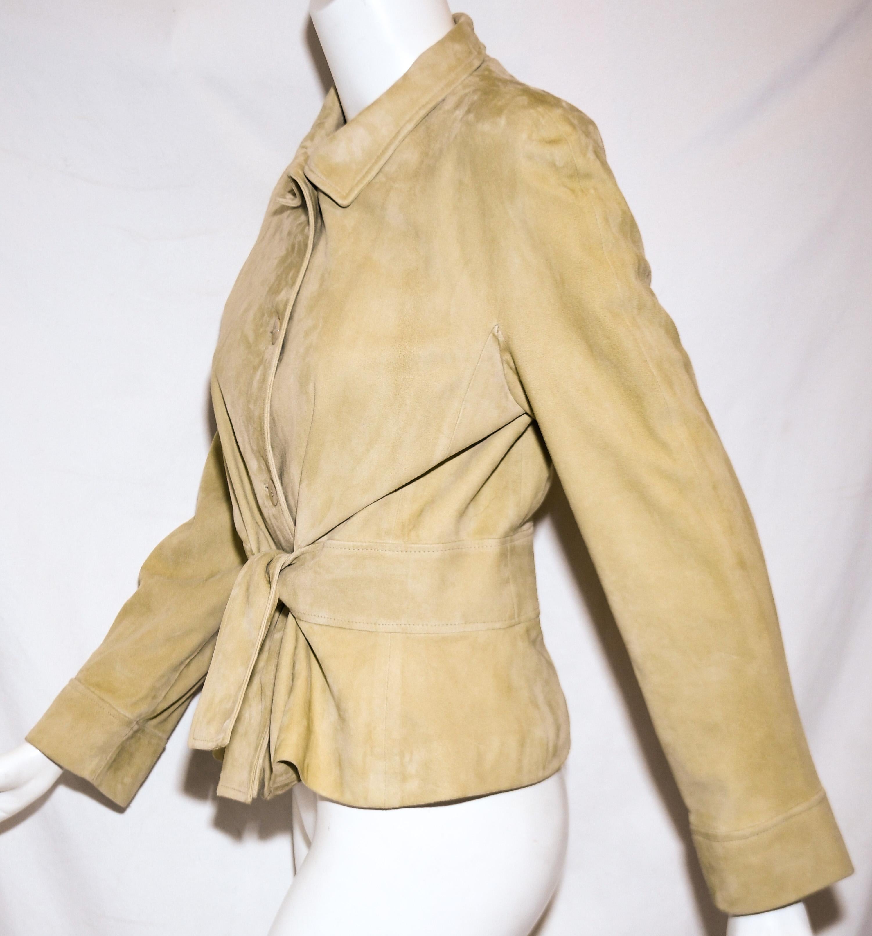 Valentino beige suede goat skin jacket includes an attached leather sash, at the waist, to be tied at front.  This jacket is lightweight and modern.  Jacket contains a shirt collar and 4 buttons at front for closure.  The jacket is fully lined in