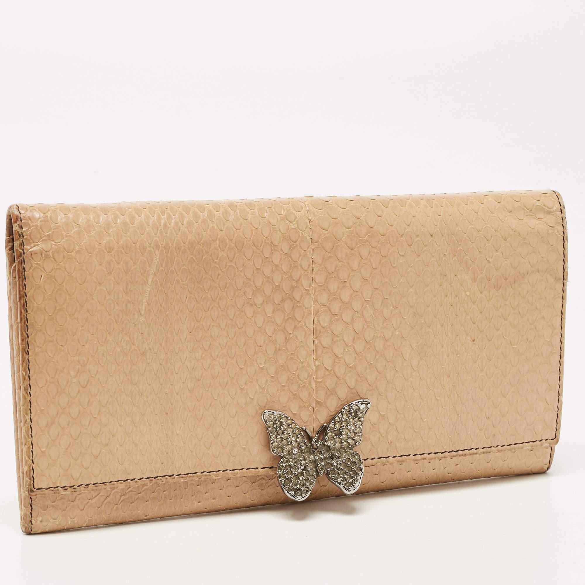 Convenient and stylish, this Valentino wallet showcases a classy design. Created from Watersnake leather, it is designed with a butterfly embellishment on the front and its lined interior is divided into different compartments.

