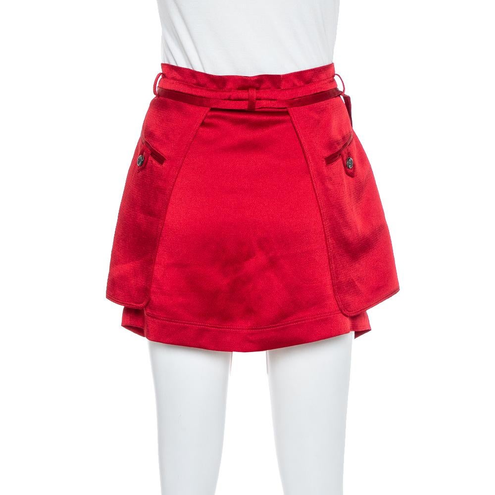 Valentino offers you a fashion-savvy approach through this mini skirt. It is tailored in satin with a short length. Flaunting a beautiful berry red hue and waist tie details and four pockets. Elevate your casual style by pairing this gorgeous cargo