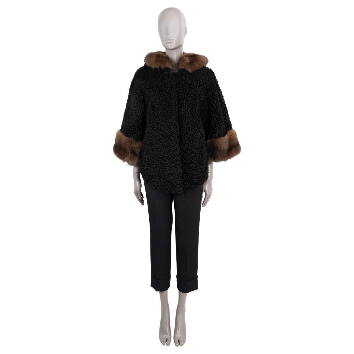 100% authentic Valentino hooded cape in black persian lamb. Features brown mink trim on the hood and cuffs, two pockets and 3/4 sleeves. Closes with a toggle and hook at the neck and is lined in leather. Has been worn and is in excellent
