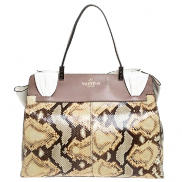This pretty bag opens to reveal a fully equipped interior lined with fabric. Crafted from patent leather, raffia and leather, this is a classy creation to own. The Valentino brand adds an elegant signature touch to this accessory. This beauty,