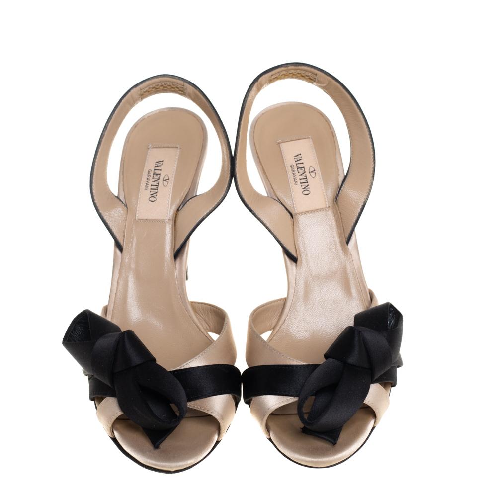 Chic, elegant and perfect for a host of occasions, these sandals by Valentino will elevate all your ensembles. They have been crafted from quality satin and come in classic shades of beige and black. They are styled with open toes, bow detailing,