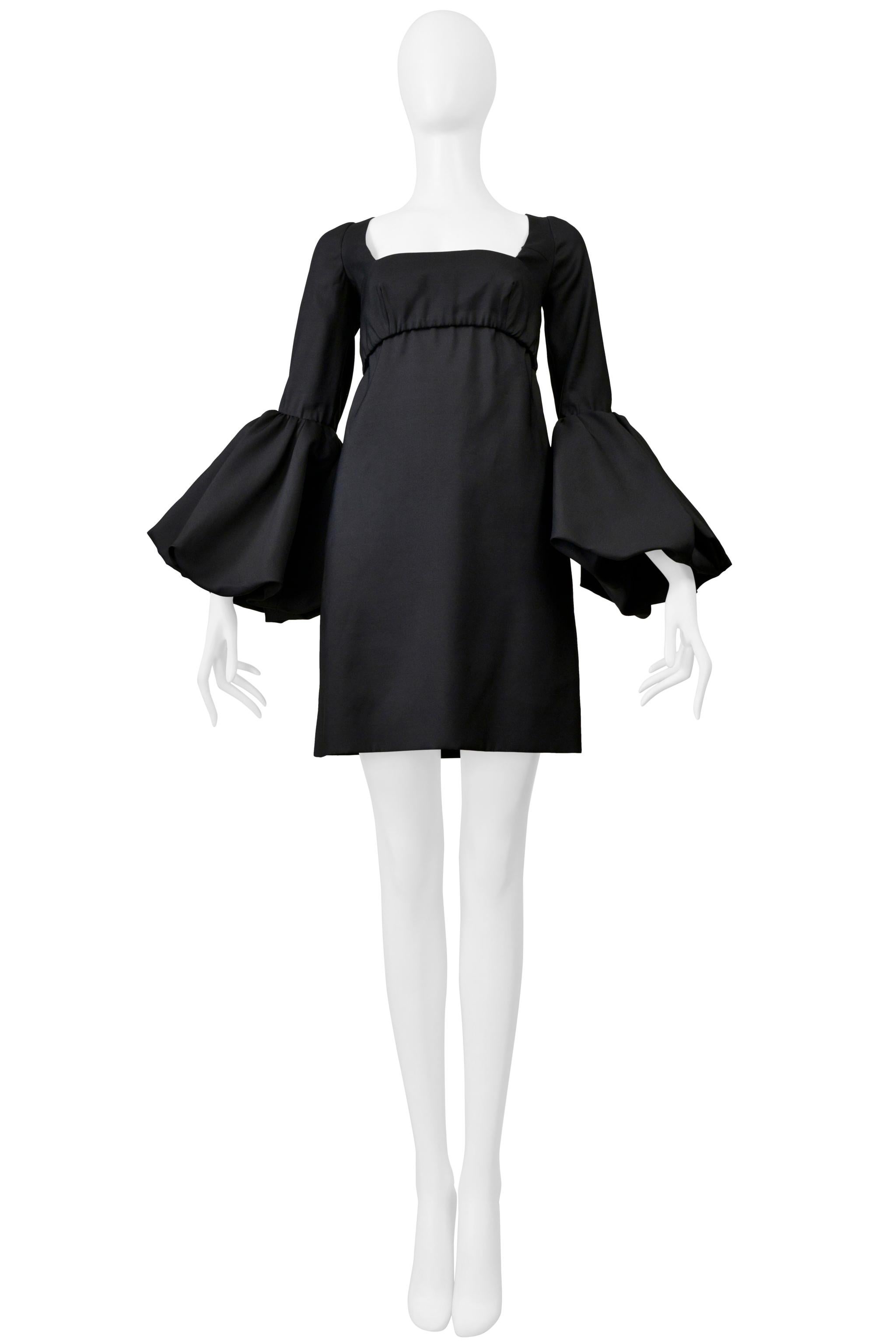 Resurrection Vintage is excited to offer a vintage Valentino black cocktail dress featuring a an attached bra top, pouf sleeves, ribbon tie, exposed back with bows, and above the knee length.

Valentino
Size 36
Fabric: 65% Virgin Wool, 35% Silk,