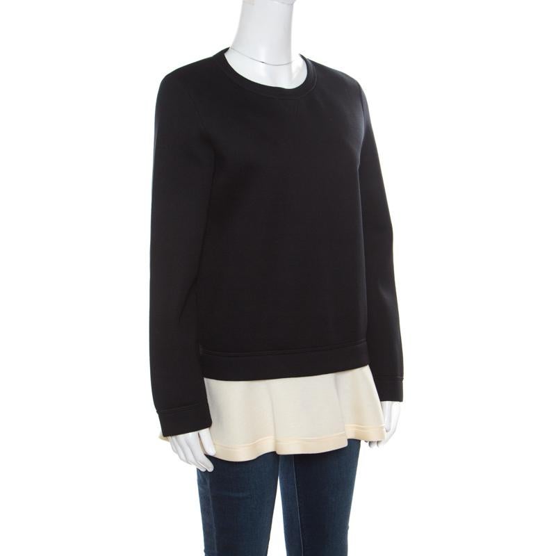 Das Sweatshirt von Valentino ist perfekt für den Freizeitlook. Der klassische schwarze Farbton wird mit einem kontrastfarbenen, ausgestellten Saum kombiniert, der dem Sweatshirt einen überraschend femininen Look verleiht. Es hat lange Ärmel, einen