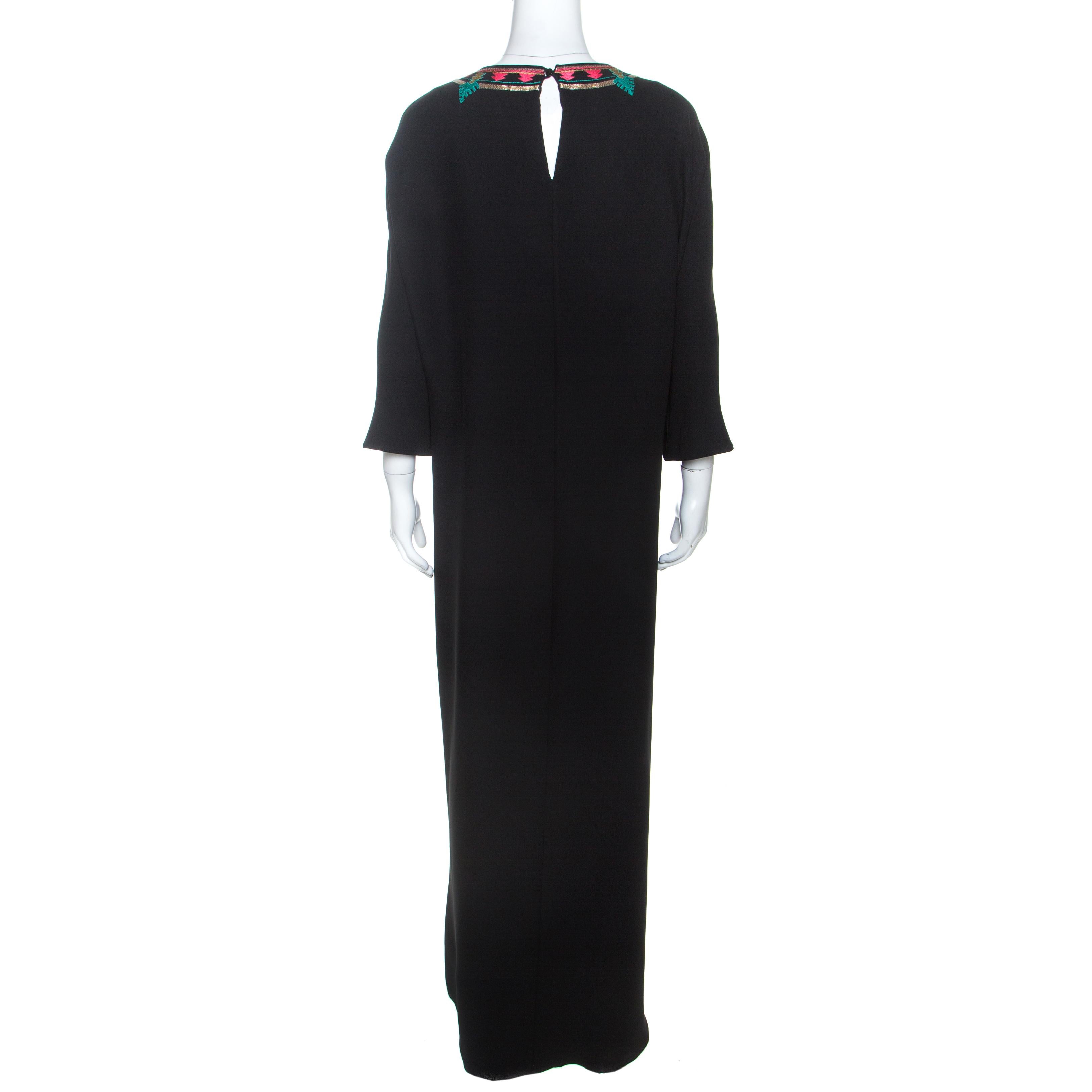 This gorgeous maxi dress from the house of Valentino is one of a kind. Crafted from 100% silk, this luxurious creation comes in a classy shade of black. It features a simple silhouette with a round neck beautified with multicolored embroidery, small