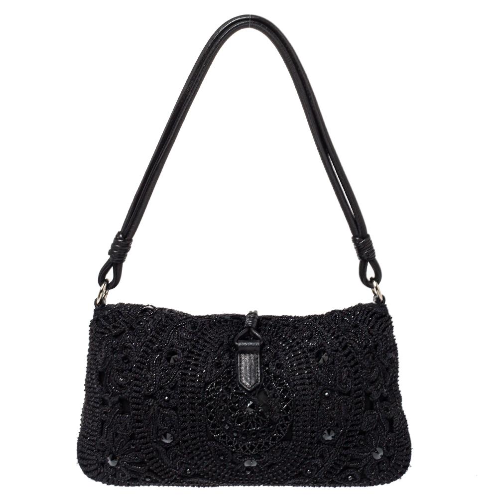 Carry this elegant and feminine hobo to your next party and notice admiring glances coming your way. Made from crochet fabric in black color, the Valentino creation is stuning. The VRing logo on the front flap is encrusted with crystals adding an