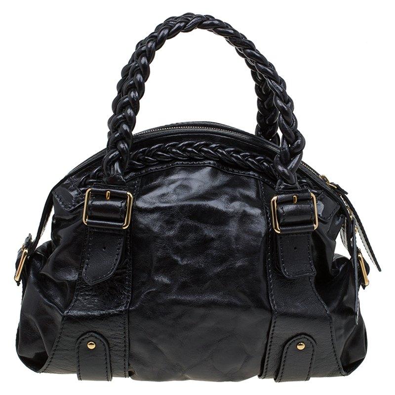 This eye-catching dome shaped satchel from the house of Valentino is a true stunner. It is made out of black glazed leather and comes with a braided handle. Decorated with golden accents, this bag comes with a top zip closure and the 'Valentino'