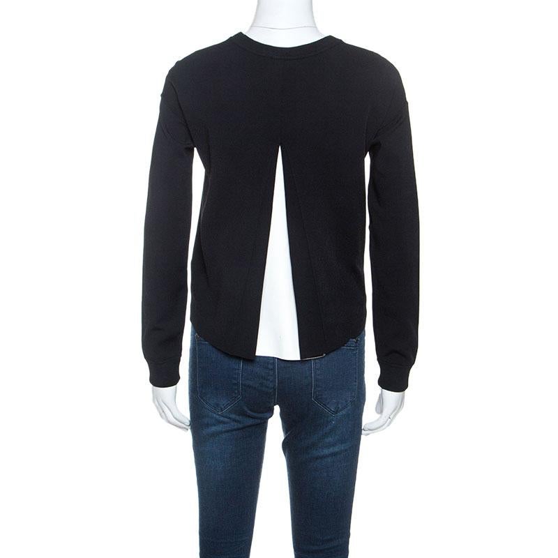 This sweatshirt by Valentino is a great example of an elevated essential. It comes in black and has a simple silhouette, featuring long sleeves, round neck, ribbed hems, and cuffs. The pleat detail at the back that showcases a contrast lining adds