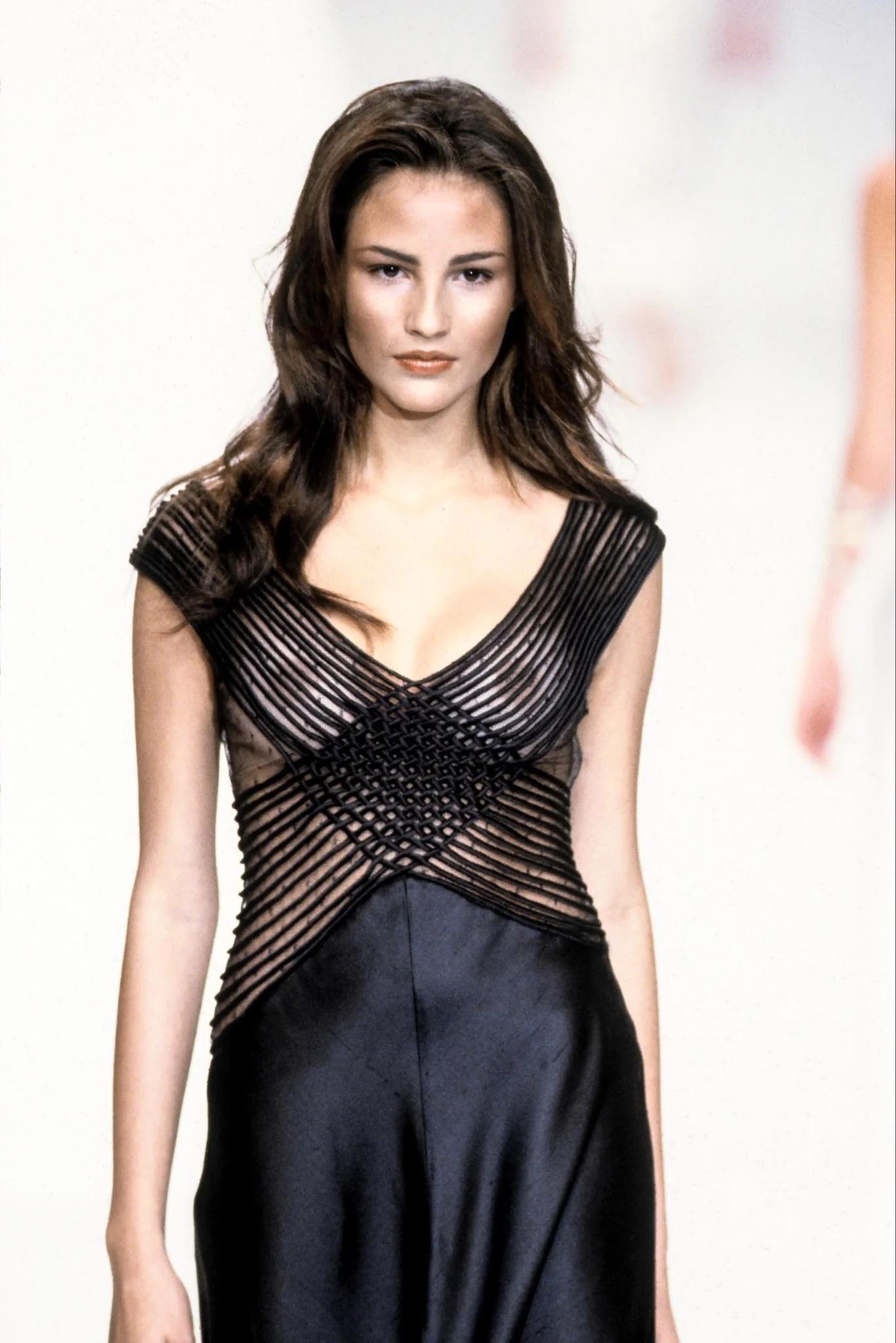 Valentino black silk evening gown, Spring Summer 1999
Modelled by Fernanda Tavares on the runway
Full-length black skirt in raw silk
Bodice is fitted and is made of a nude silk under-layer which is overlaid with black silk corded ribbon work,