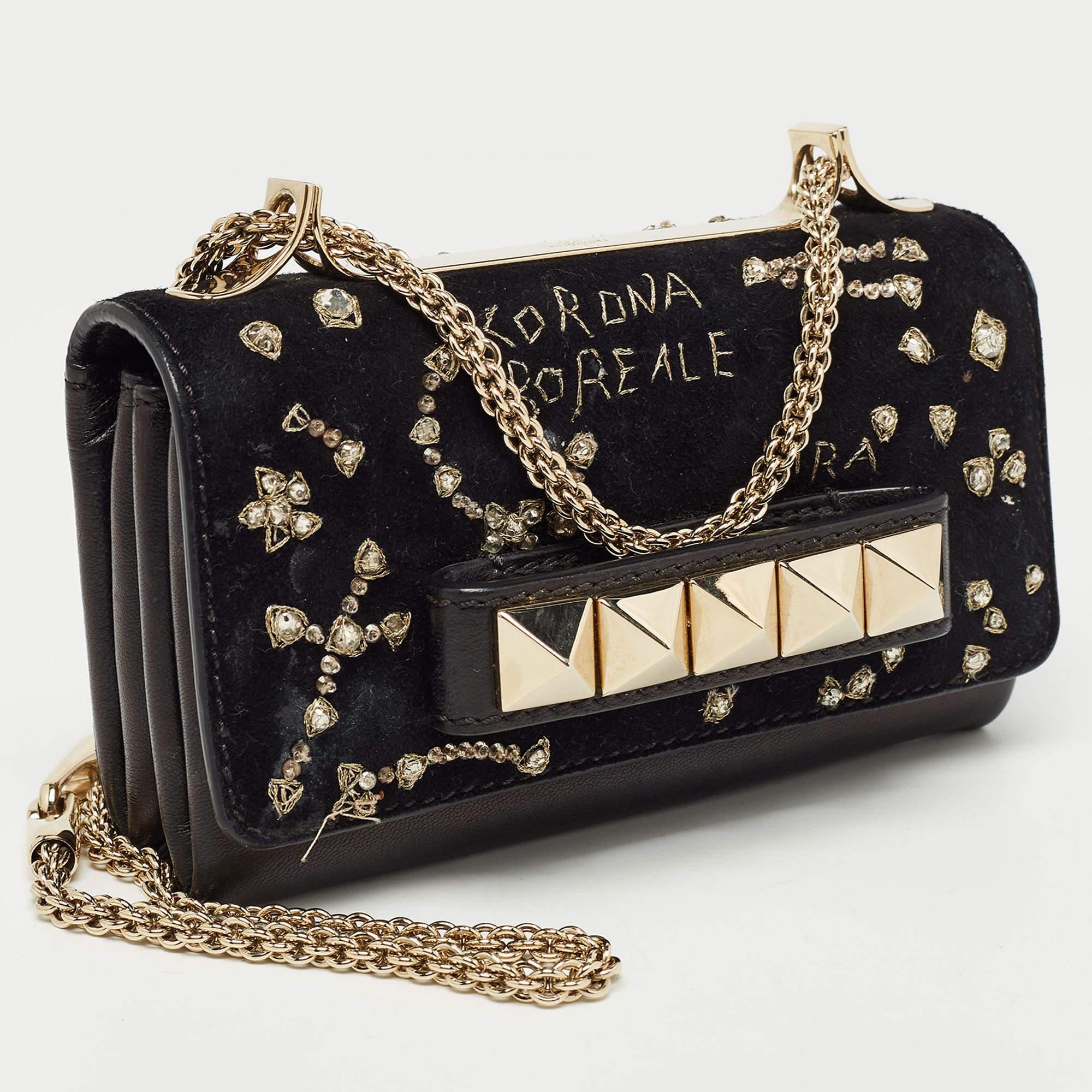 This Va Va Voom clutch bag from Valentino has a pretty captivating design. Crafted from suede and leather, the bag features gorgeous a flap, a leather interior, and a shoulder chain. It also comes with a hand slot that is decorated with their