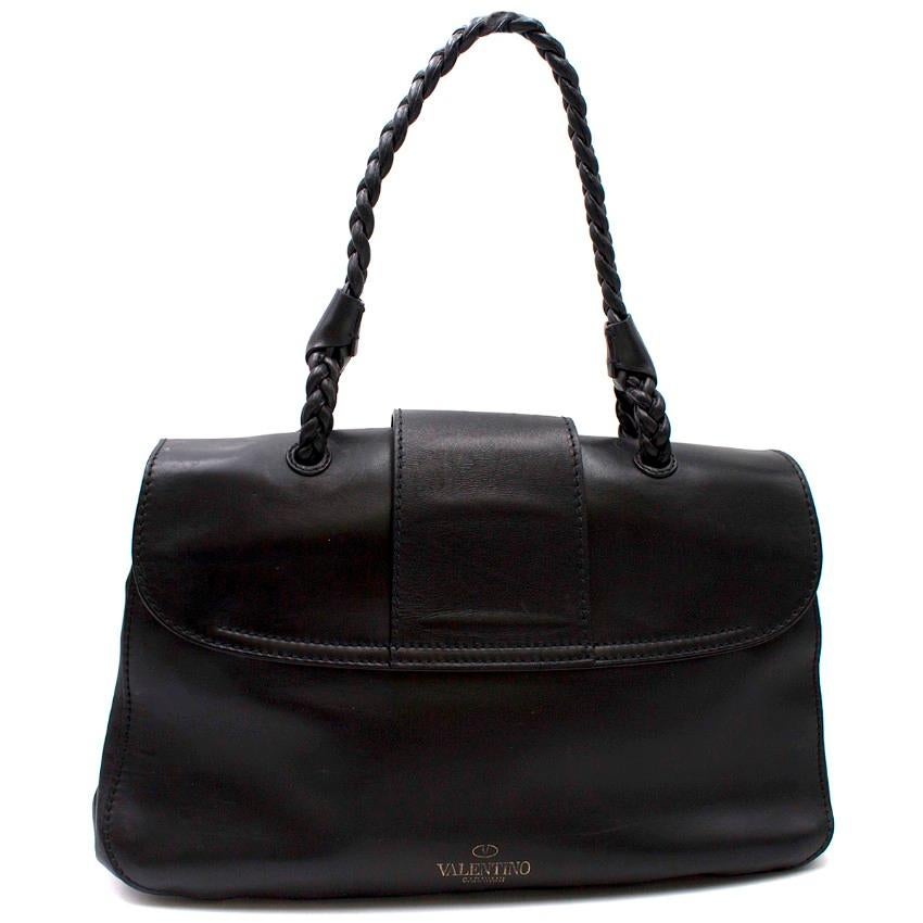 Valentino Black Leather Braided Handle Shoulder Bag

- Black leather handbag
- Leather braided handle and tuck fold detail
- Foldover flap closure which tucks into a braided top to fasten
- Gold-tone metal feet
- Two spacious main compartments