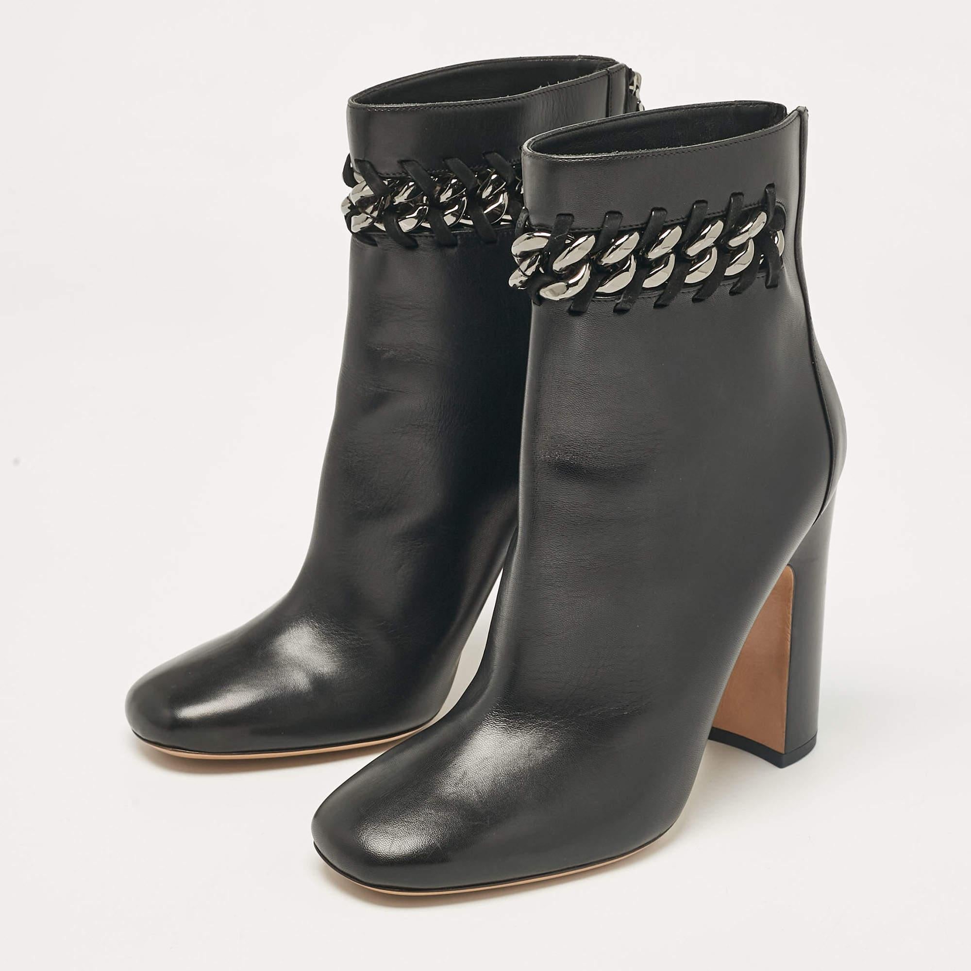 Élevez votre jeu de chaussures avec ces bottines de Valentino. Fabriquées en cuir, elles présentent des orteils carrés et des semelles intérieures doublées de cuir. La paire est montée sur des talons blocs et est agrémentée de maillons de chaîne