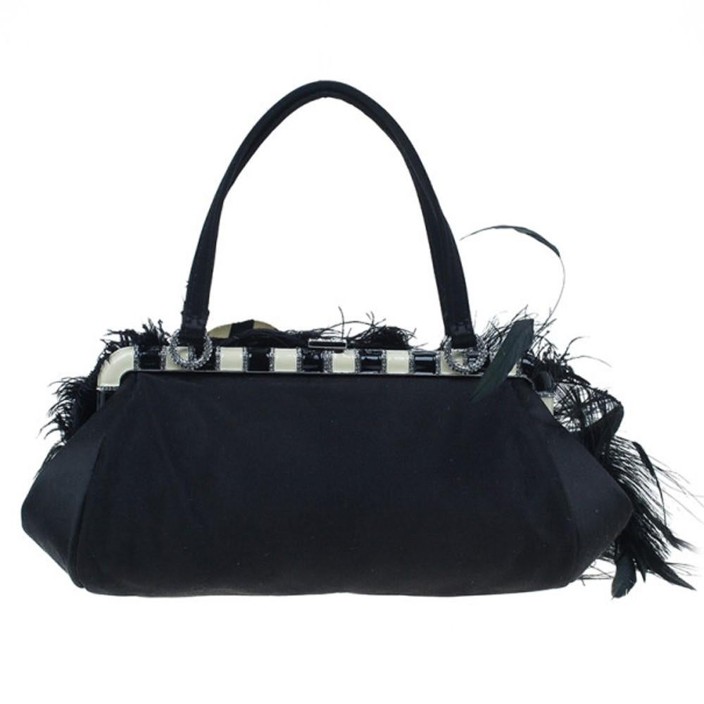 This gorgeous black Valentino feather satchel won't let you go unnoticed. The bag features feather embellishments along with a ribbon flower at the front and crystal embellishments at top and hinge closure. The interior displays a satin lined