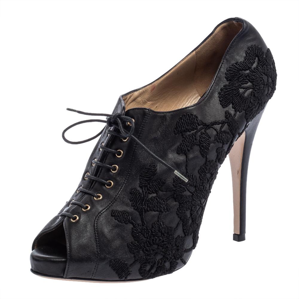 Strut the street wearing these Valentino ankle booties and leave the bystanders admiring your style. It is crafted from floral embroidered black leather with peep toes. The pair is complete with lace-up closure and comfortable leather-lined insoles.