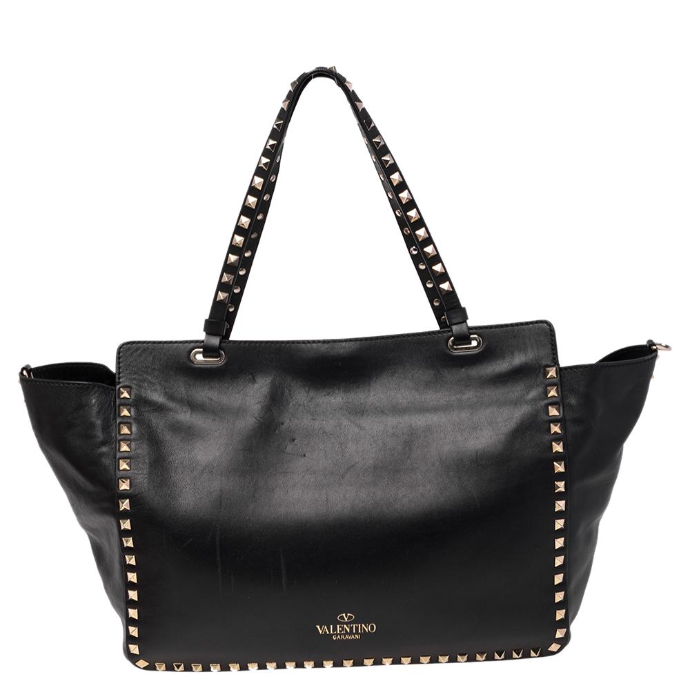 Luxury Italian fashion house Valentino is famed for its classic designs infused with its own signature modern edge and Rockstud details as showcased by this Trapeze tote. Crafted from black leather, it features top handles and a detachable shoulder